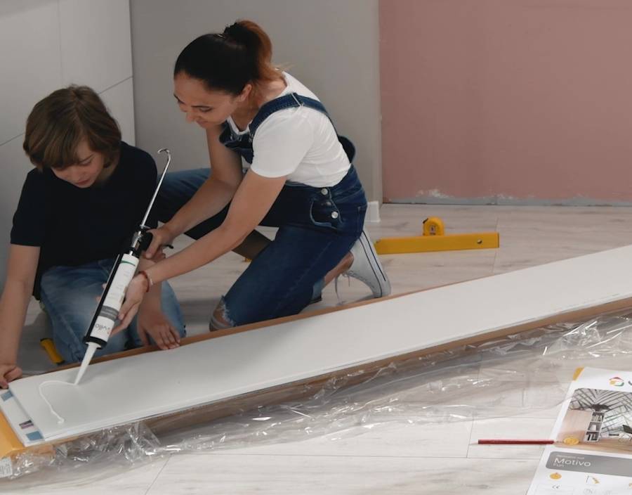 kobieta samodzielnie nakłada klej na lamele ścienne