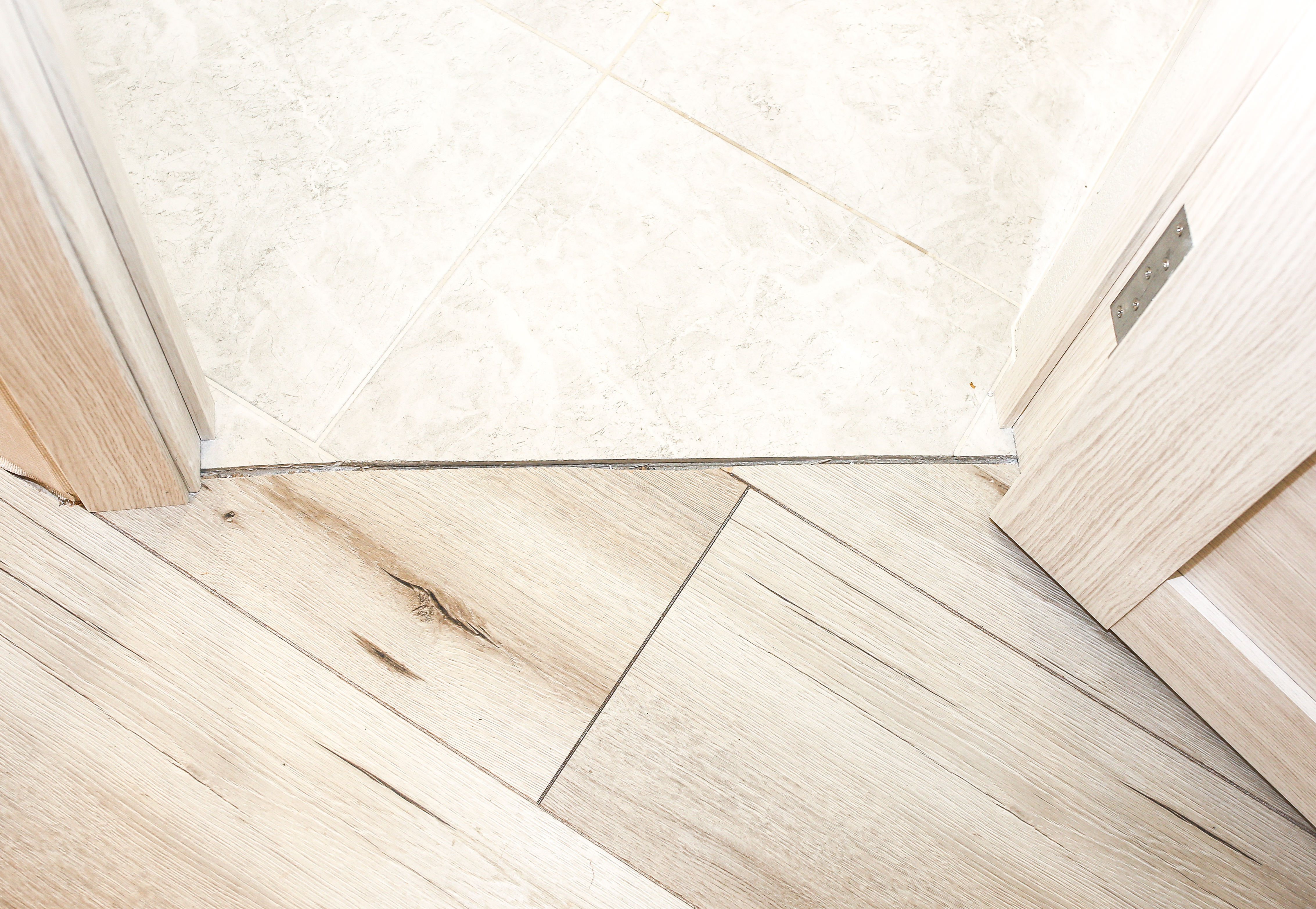 szczelina dylatacyjna w progu między płytkami a panelami