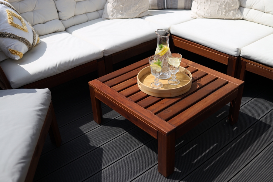 drewniany stolik i komplet wypoczynkowy na kompozytowym tarasie